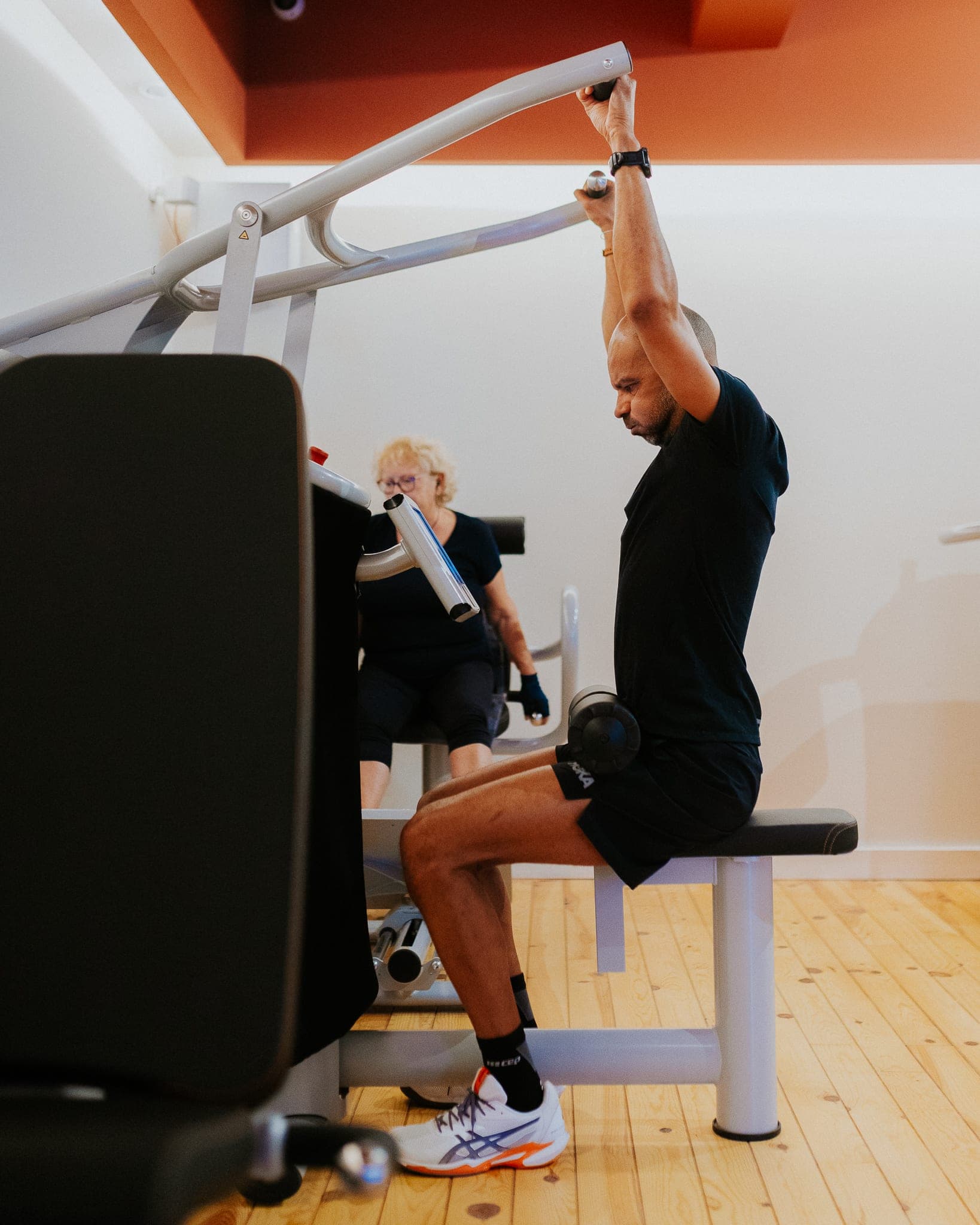 Membre en séance, cadré à travers une machine EGYM