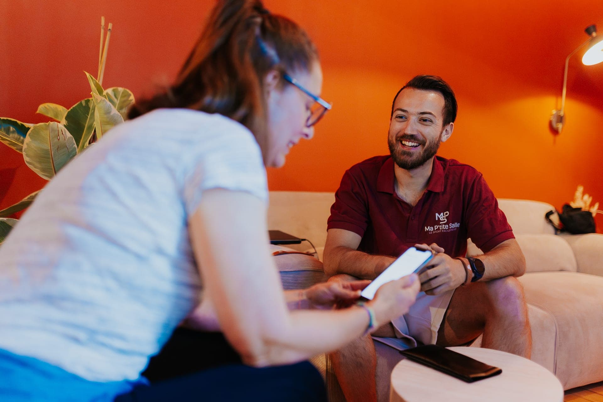 Coach Ma P'tite Salle en discussion avec une membre sur le canapé
