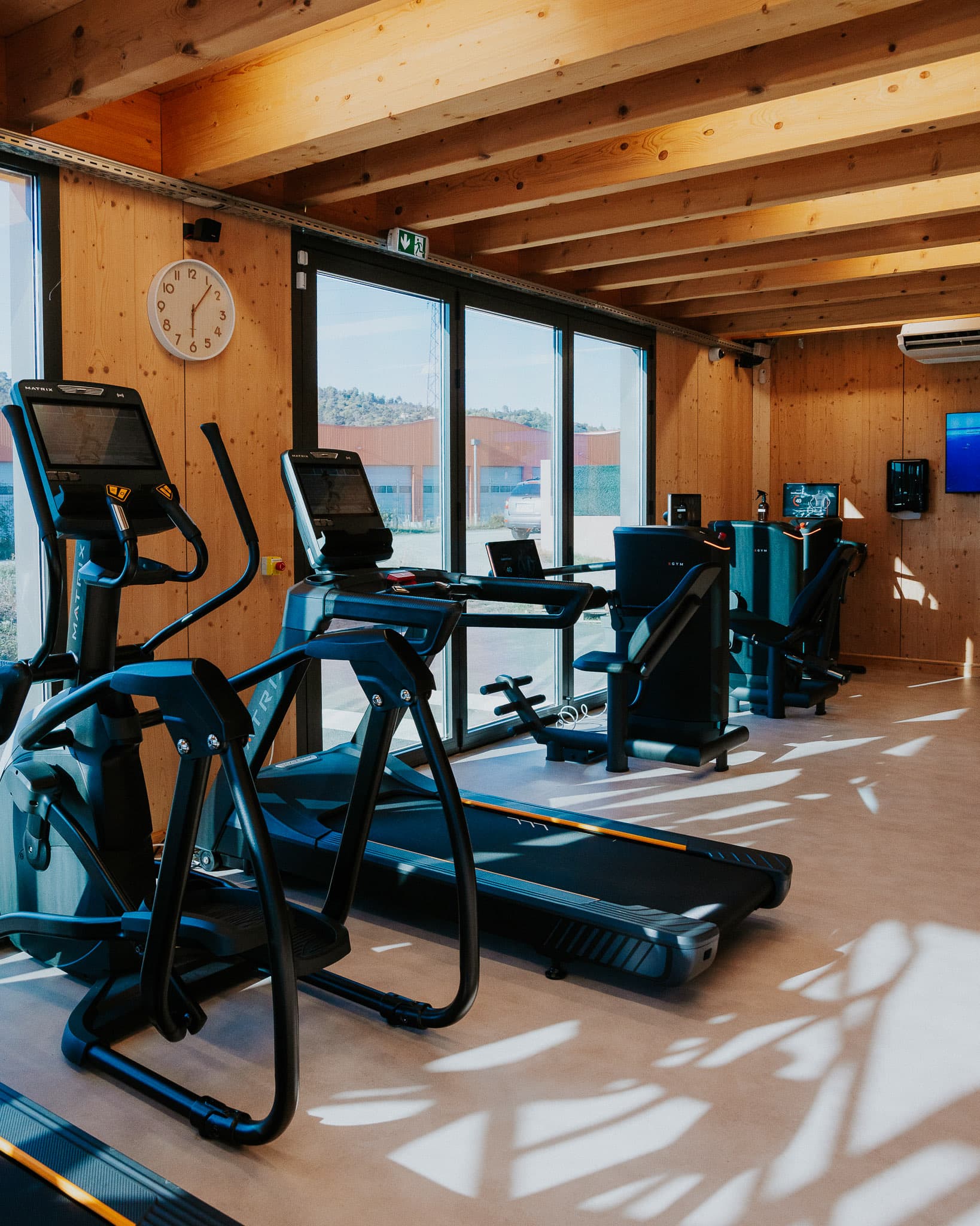 Espace cardio : vélo elliptique et tapis de course face aux baies vitrées